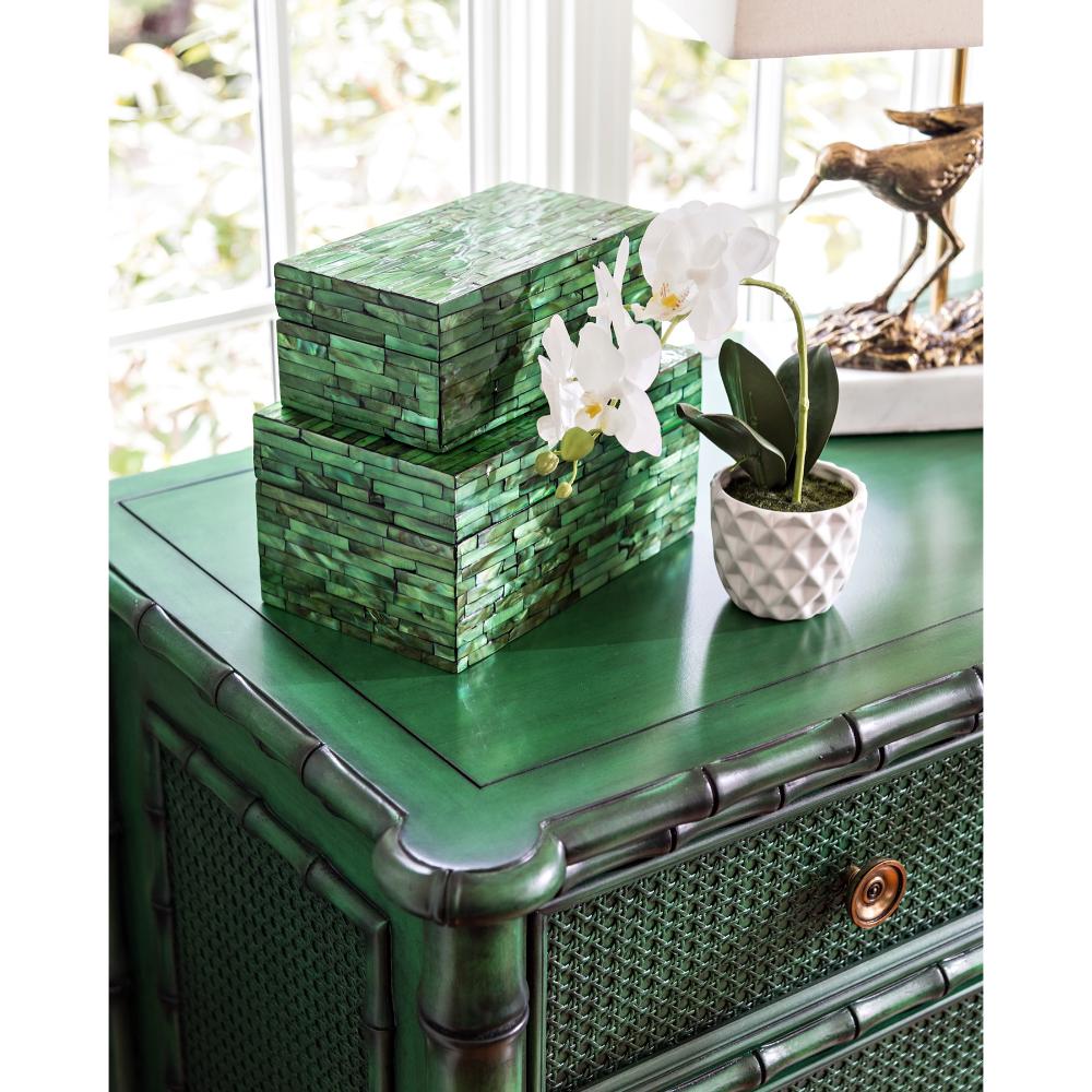 green painted rattan and cane chest with green capiz shell mosaic clad decorative boxes and white orchid in pot