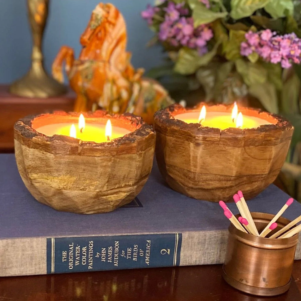 two lit round wood "endurance" candles on a book