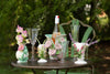 A round table is adorned with Abigails' Handmade White + Pink Rose Vase, glassware, and a wine bottle in the garden.