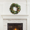 A Grand Magnolia Leaf Wreath from Napa Home & Garden hangs above a white brick fireplace with a burning fire in the hearth, perfect for interior use.