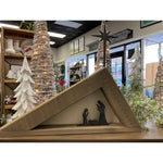 Brayden & Brooks' Reclaimed Wood + Canvas Nativity Scene framed in a triangle with trees and holiday decor in the background.