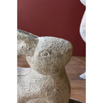 Kalalou Rustic Metal Rabbits, set of 2, ideal for garden decor against a dark red background.