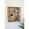 The Kalalou Wood Spindle Oval Wall Shelf holds books, a camera, succulents, and sits next to a snake plant.