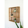 Stylish storage: Kalalou's Wood Spindle Oval Wall Shelf with plants, books, and a vintage camera on a white wall.