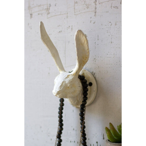 Kalalou's Antique White Cast Iron Rabbit Wall Hook with long ears and black beads adds charm to a textured white wall.