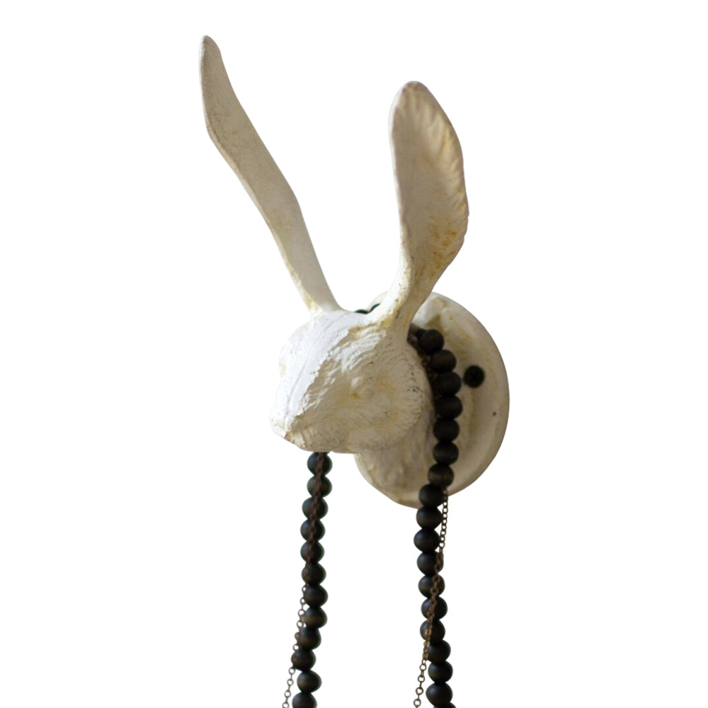 Kalalou's Antique White Cast Iron Rabbit Wall Hook with long ears and black beads adds charm to a textured white wall.