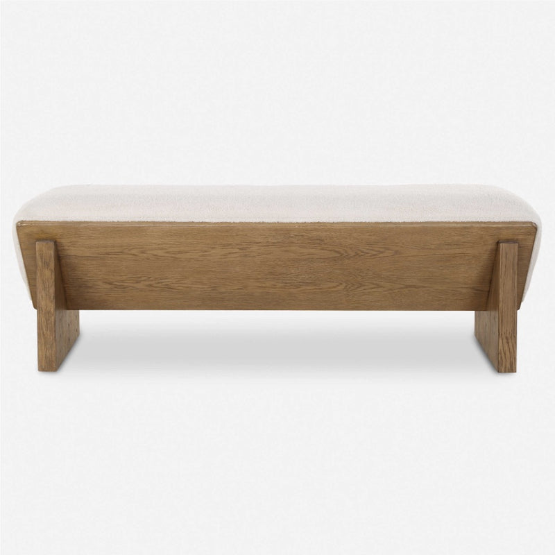 Uttermost's Wedged Bench boasts a chunky wood design with a beige cushioned top and an elegant faux sheepskin seat, set against a white background.