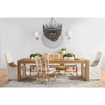 The dining room exudes a contemporary vibe with the Essentials for Living Adler Expandable Dining Table, an eclectic array of chairs, vibrant greenery, a round mirror, and an elegant beaded chandelier.