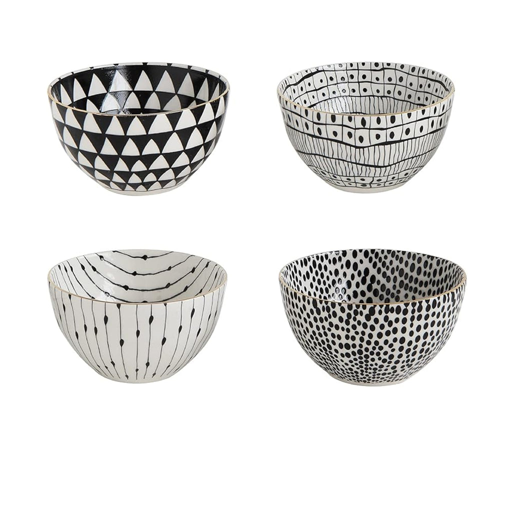 The Black + White Stoneware Soup Bowls with Gold Rim (set of 4) from Creative Co-Op, each featuring unique black and white geometric patterns and accented with subtle gold electroplating, are arranged in a 2x2 grid on a white background.