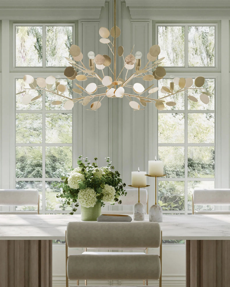 Elegant dining room featuring a Currey & Company Lunaria Silver Oval Chandelier, large window, and flower-adorned table.