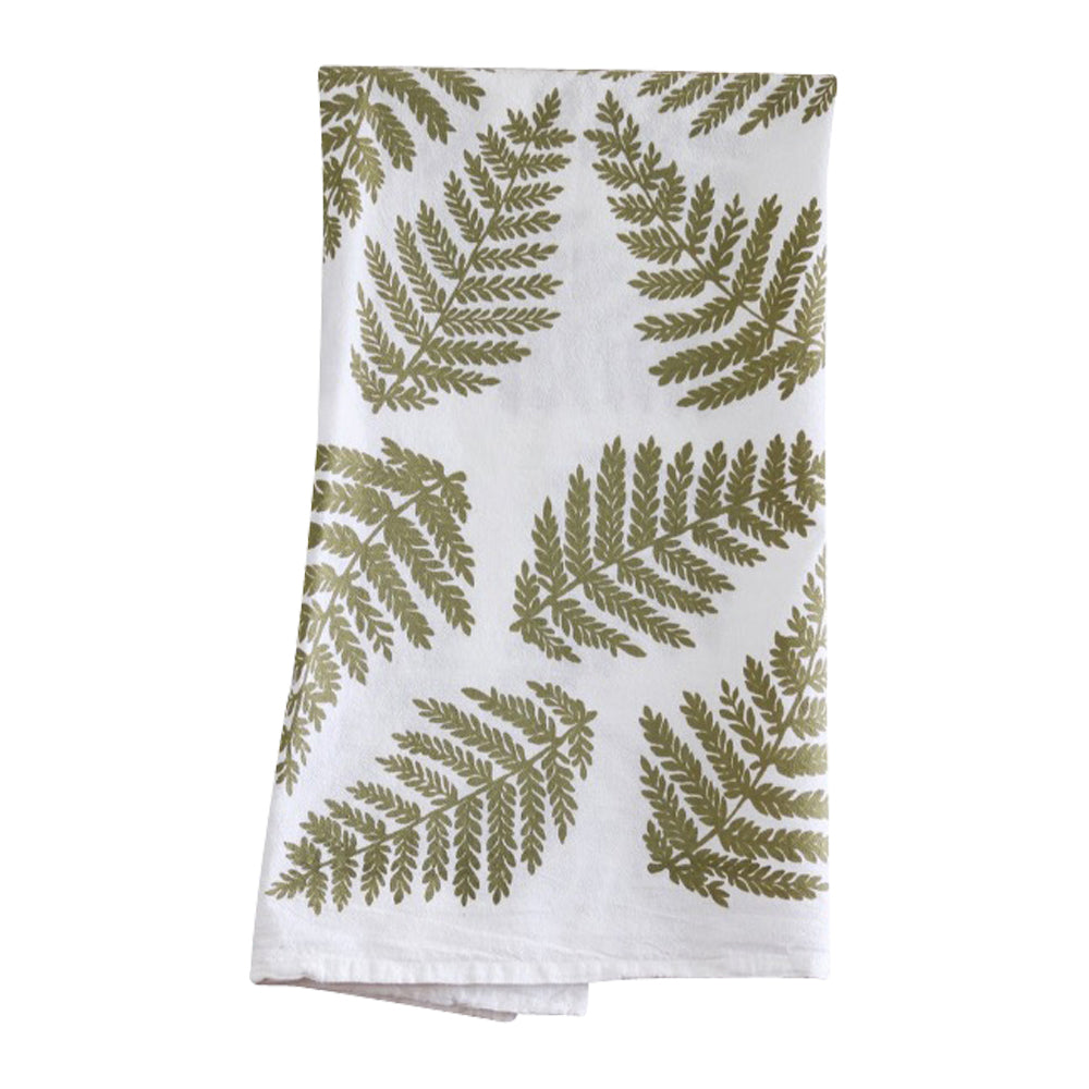 The Green Ferns Flour Sack Kitchen Towel by Muse Textiles, made from 100% heavy duty cotton and featuring green fern leaf patterns scattered throughout, is an eco-friendly addition to any kitchen. This stylish white tea towel is folded and displayed against a white background.