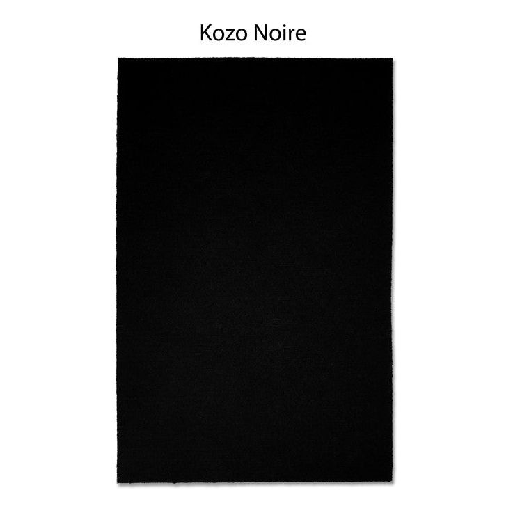 A black rectangular rug featuring the elegant "Kozo Noire" design, inspired by the sophisticated aesthetic of Japanese mulberry paper.