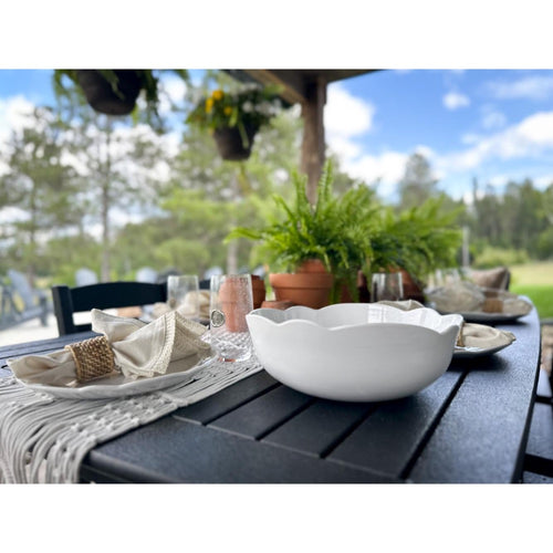 scalloped white serving bowl on table