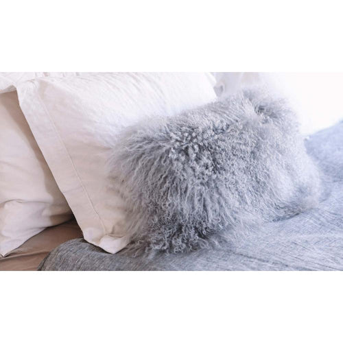 pillow longwool sheepskin lumbar gray rests on a neutral bed