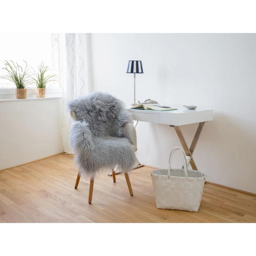 Gray Tibetan sheepskin rug laid on a desk chair in front of a white desk