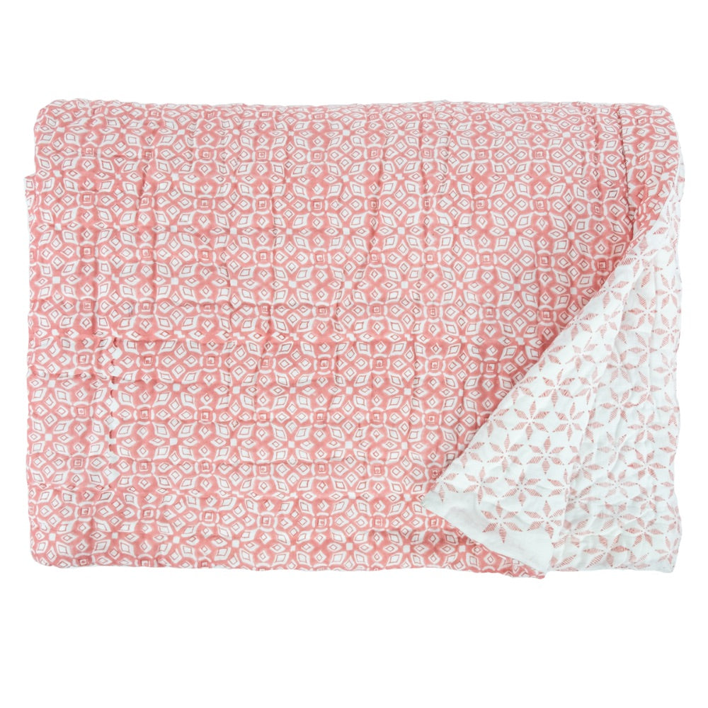 The Lara Coral Quilt by Allem Studio is a reversible, hand-quilted quilt in pink and white with a geometric pattern, showcasing both sides of the exquisite fabric.